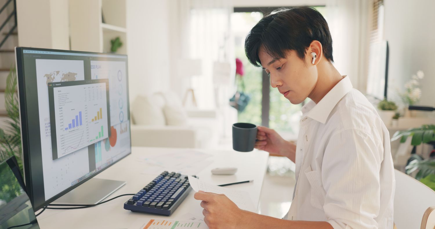 An investor reviews financial charts and macroeconomic data on a computer screen