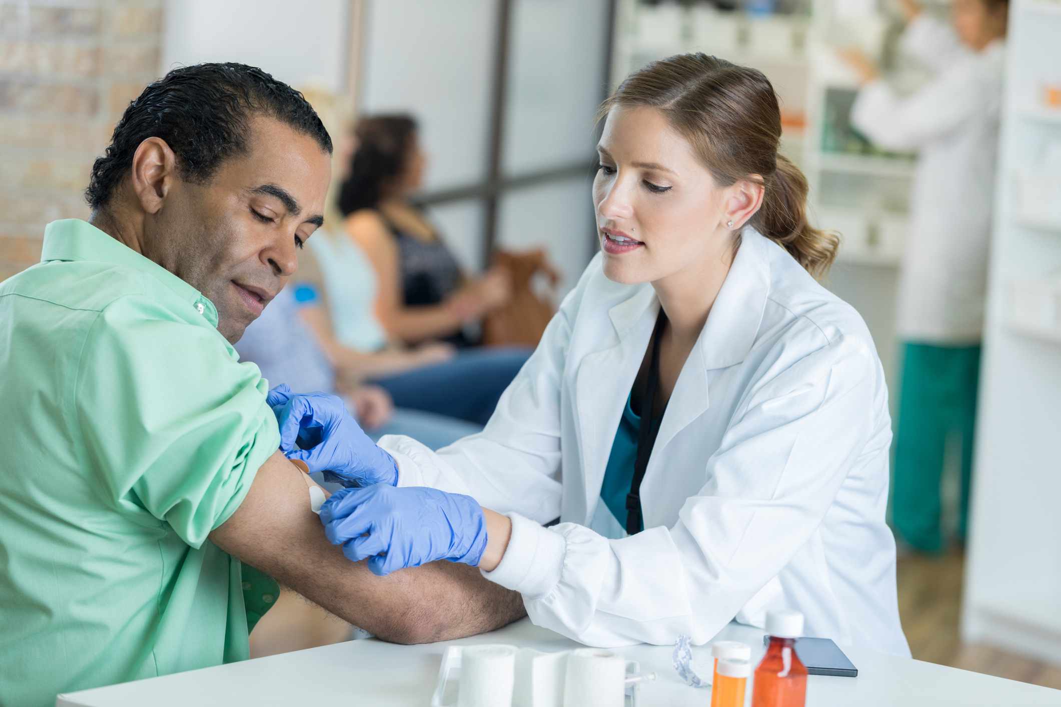 A doctor applies a bandage after a shot.