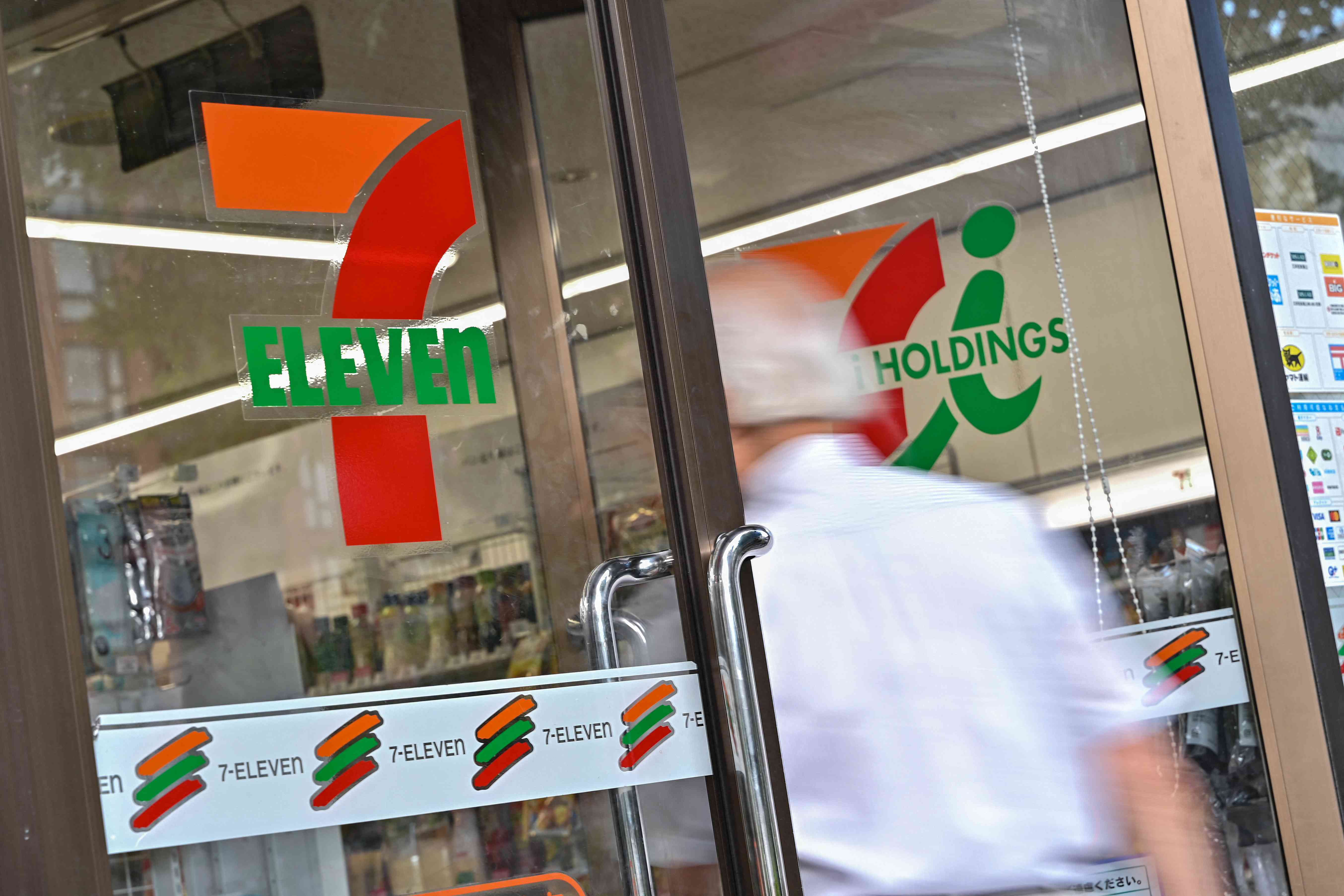 A customer enters a 7-Eleven convenience store along a street in central Tokyo on September 9, 2024