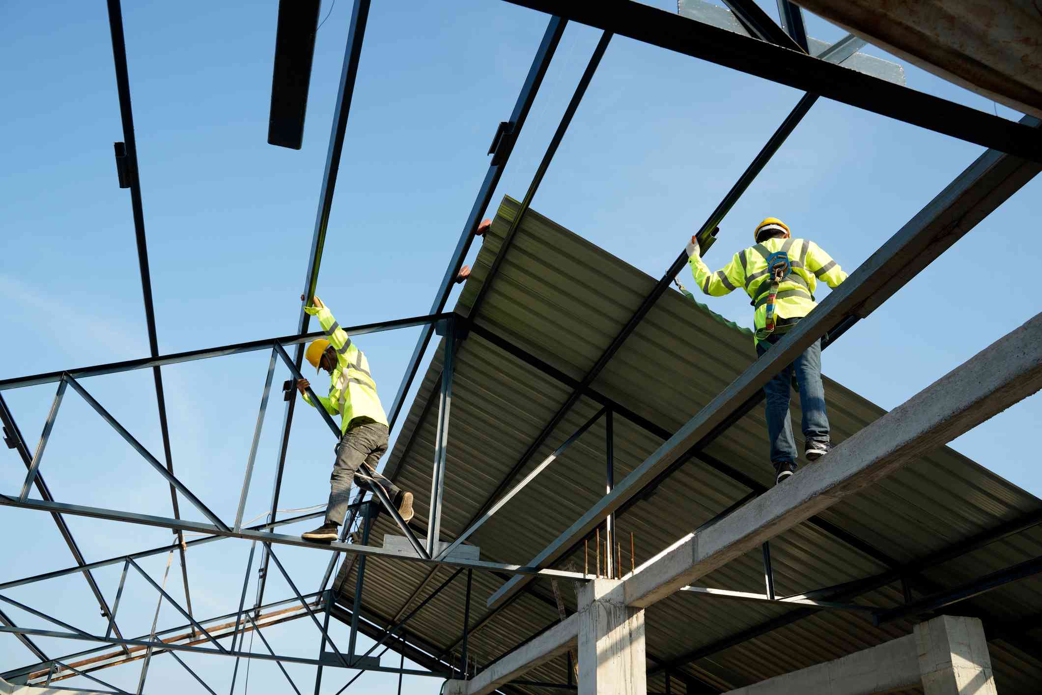 Workers installing steel roof sheet