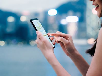 Woman checking financial trading data with smartphone in city