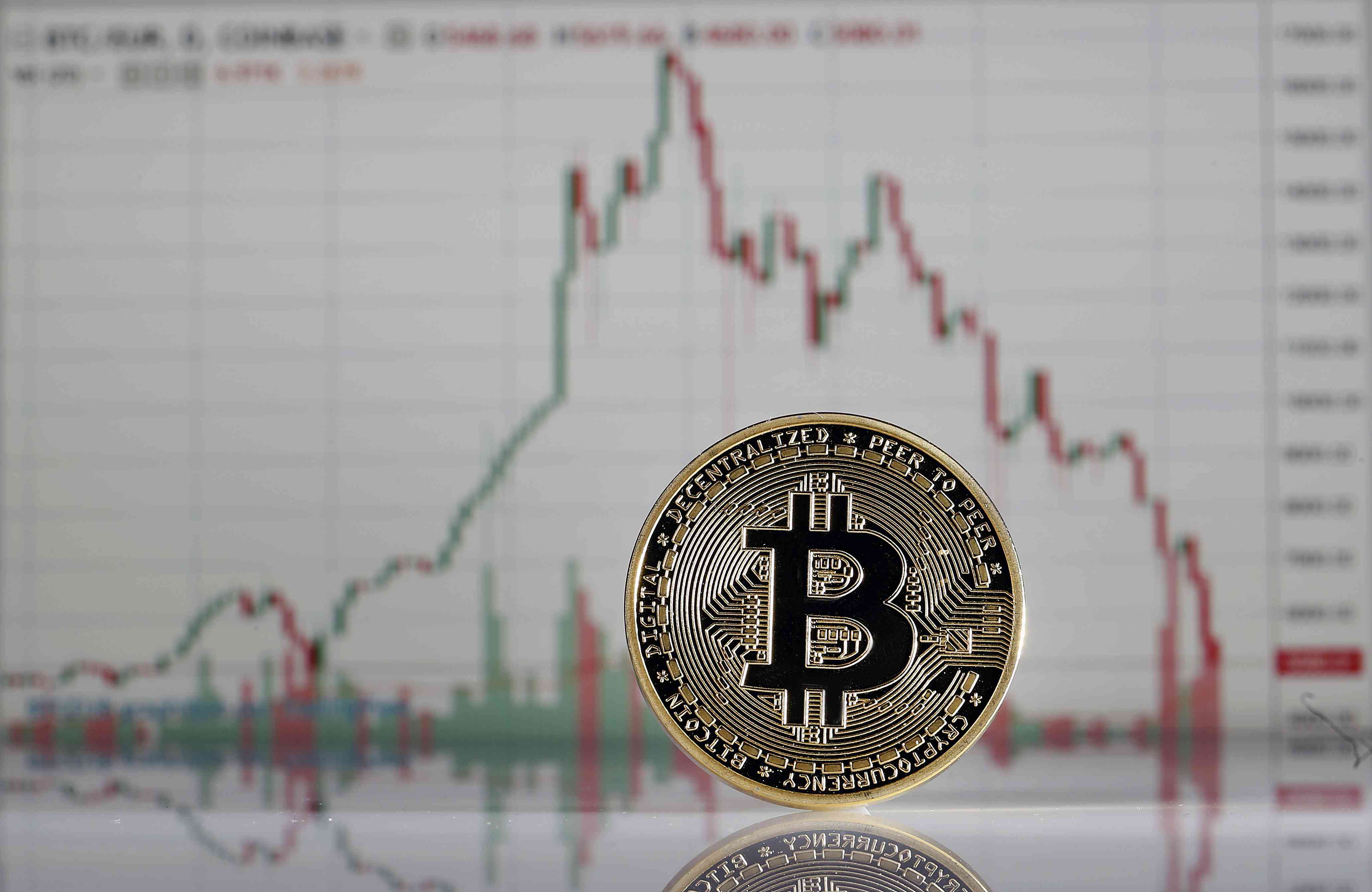 In this photo illustration, a visual representation of the digital Cryptocurrency, Bitcoin is displayed in front of the Bitcoin course's graph of Coinbase cryptocurrency exchange website on February 6, 2018.