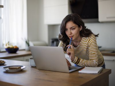 Young woman using a laptop while working from home.