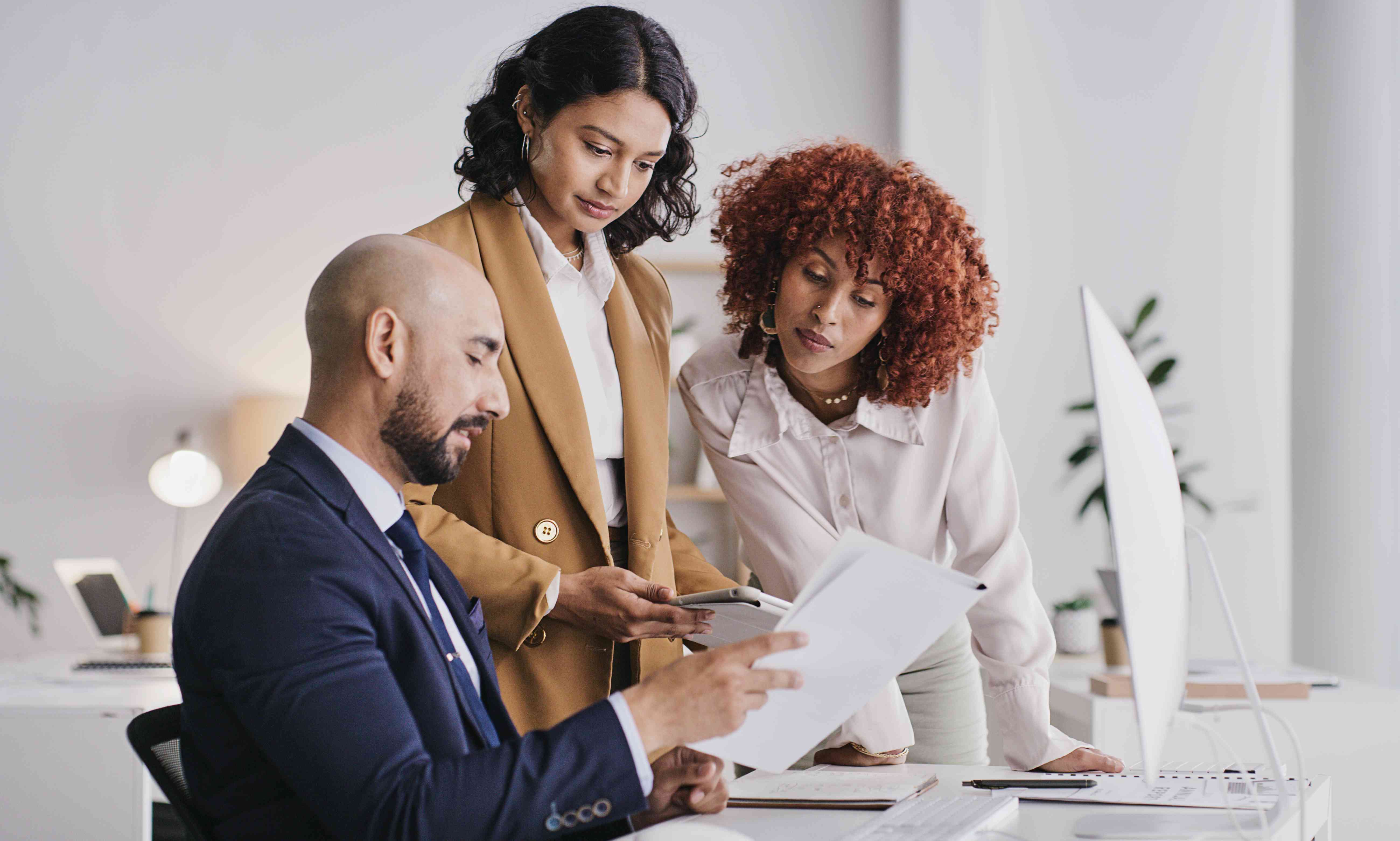 Three people in an office looking at paperwork