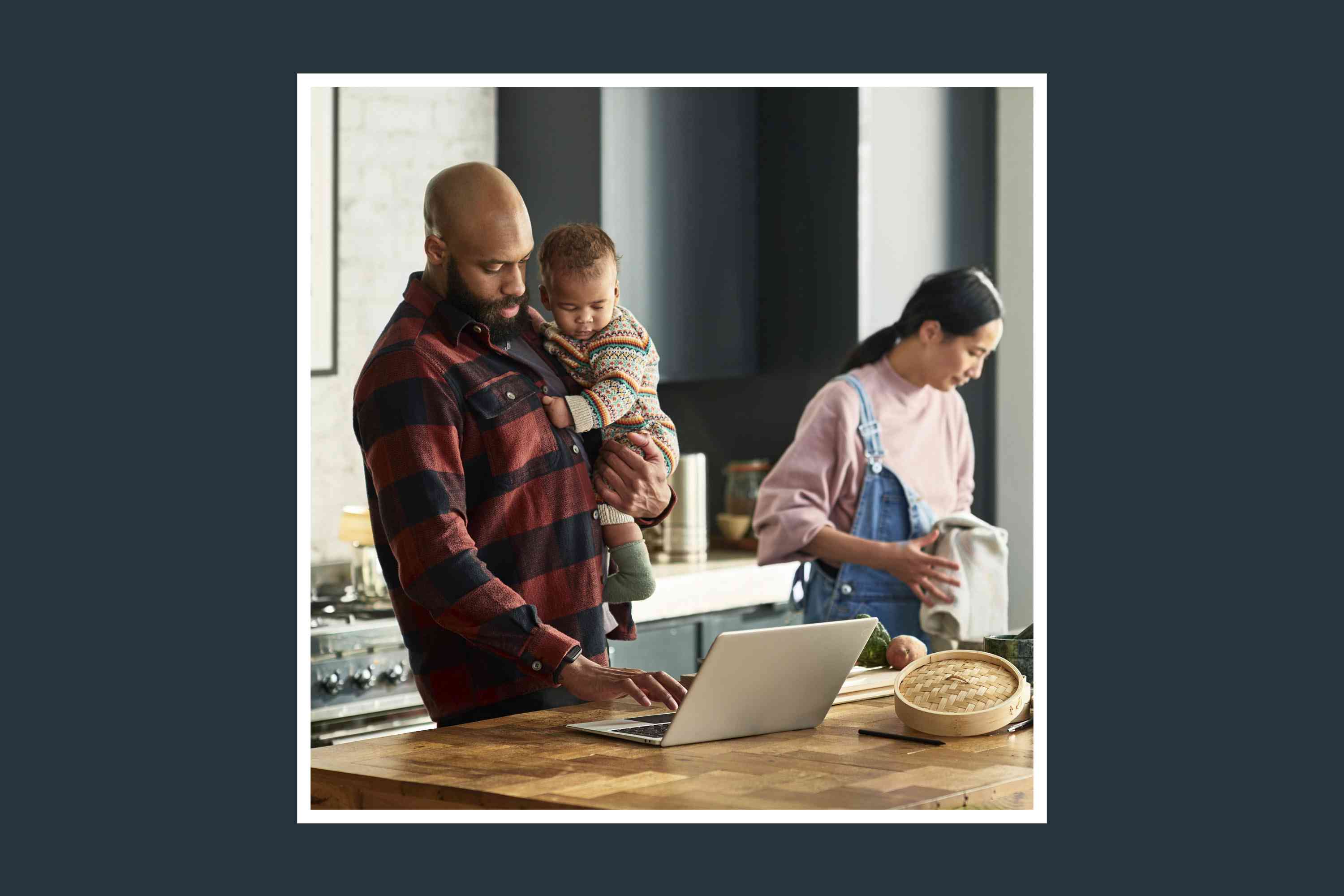 couple in their kitchen holding a baby