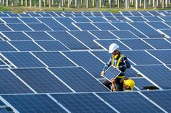 Two workers installing solar panels.