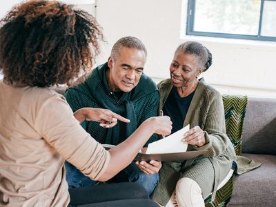 A woman shows papers to an older couple