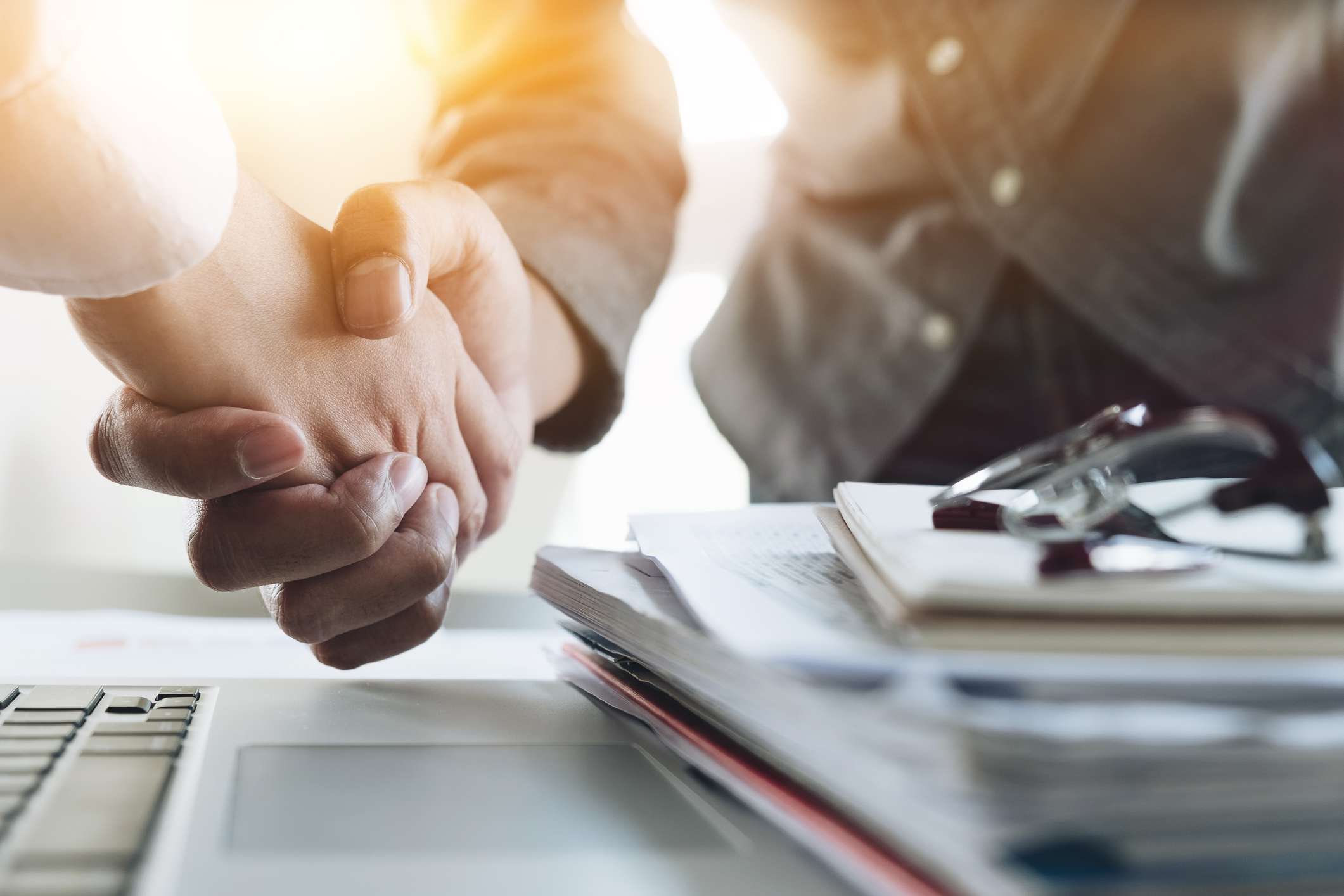 Close-up of business people shaking hands, finishing up meeting.