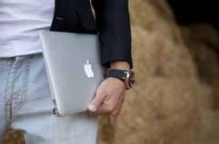 Close up of a person holding holding Apple's 13" MacBook Air laptop