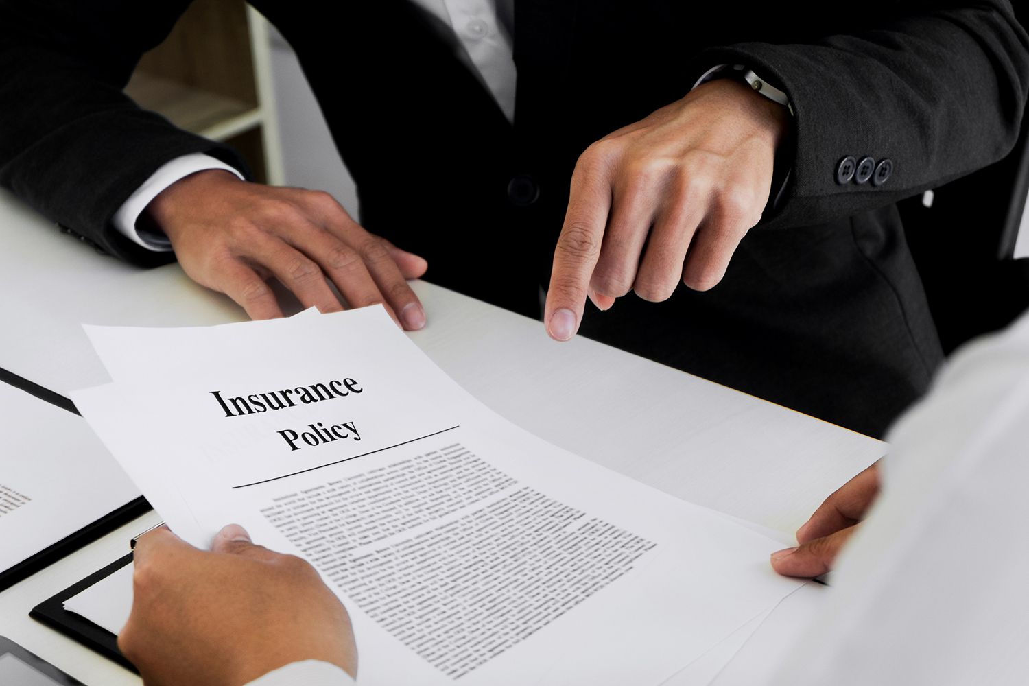 Midsection of Businessman Explaining Insurance Policy to Customer in Office