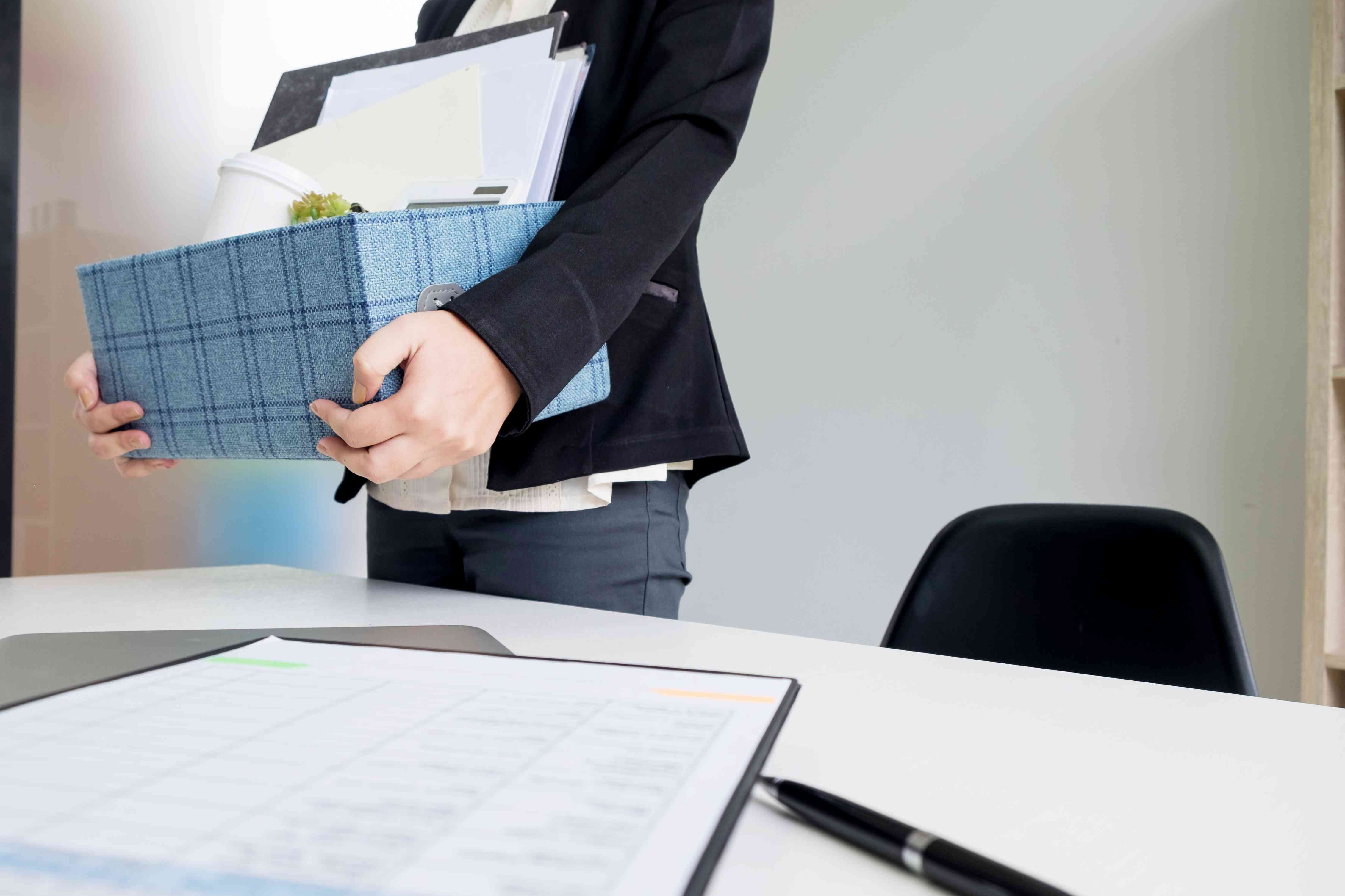 Midsection Of Woman Holding Box By Table At Office