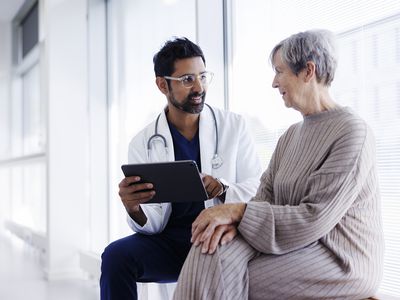 Doctor and patient in conversation, looking at digital tablet