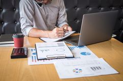 Midsection of Businessman Talking Over Smart Phone While Working at Desk in Office