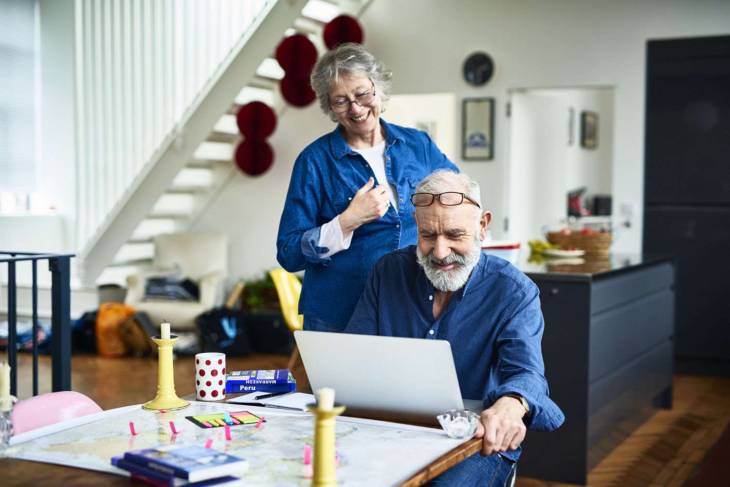 Cheerful Retired Couple at Home Planning Vacation