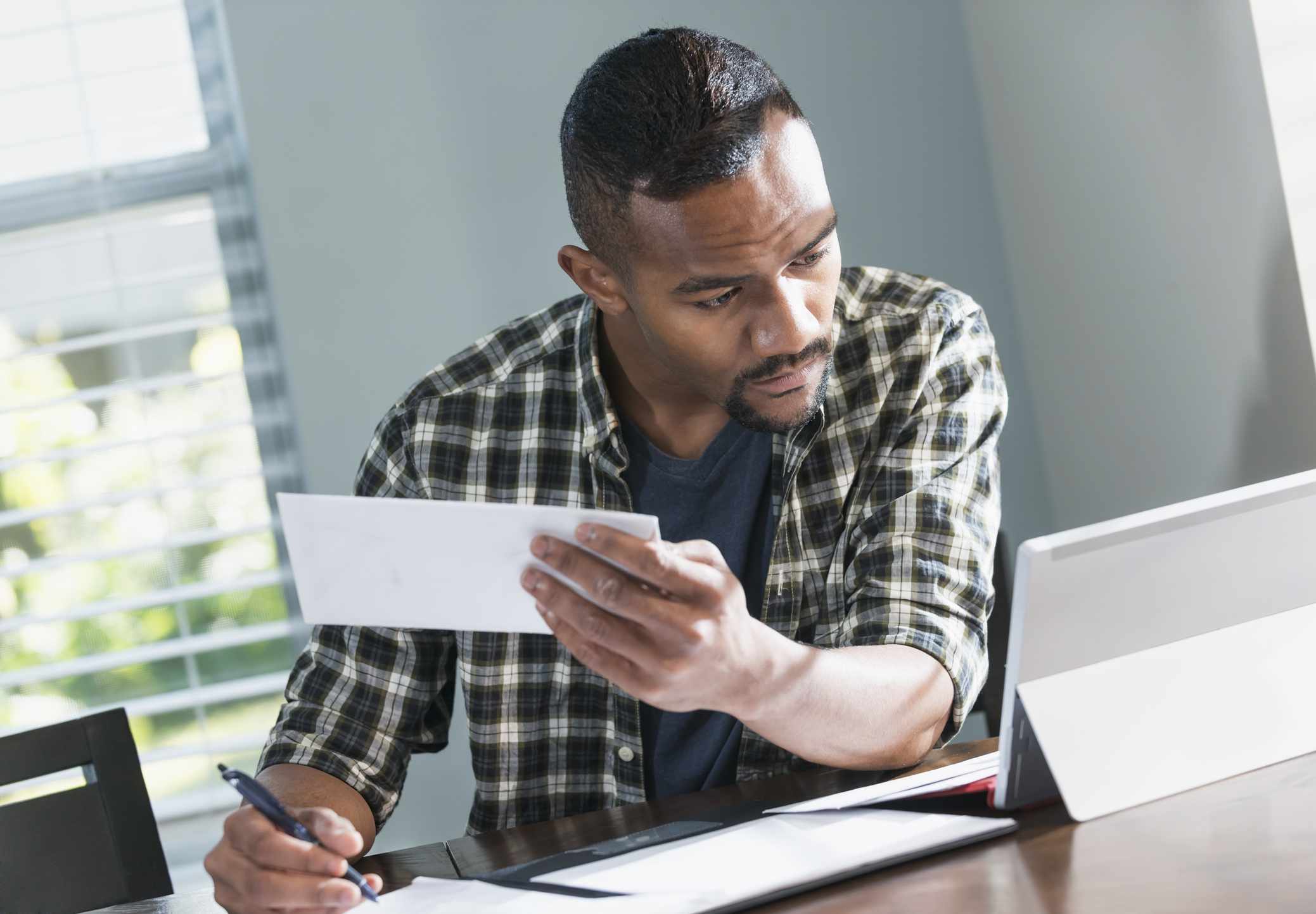 A man at a desk pays bills.