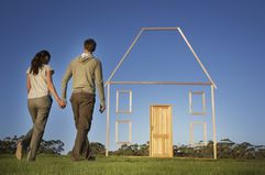 A couple walking toward a vertical house outline.