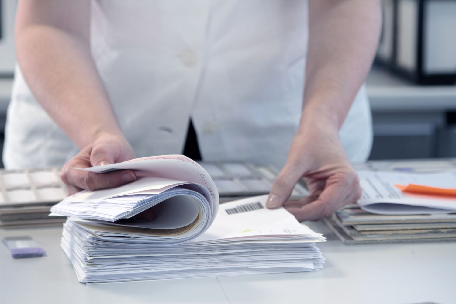 A person flipping through a stack of paperwork