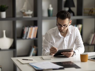 A man sits at a desk with paperwork.