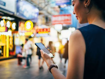 Young Woman Using a Smartphone in Busy City Street