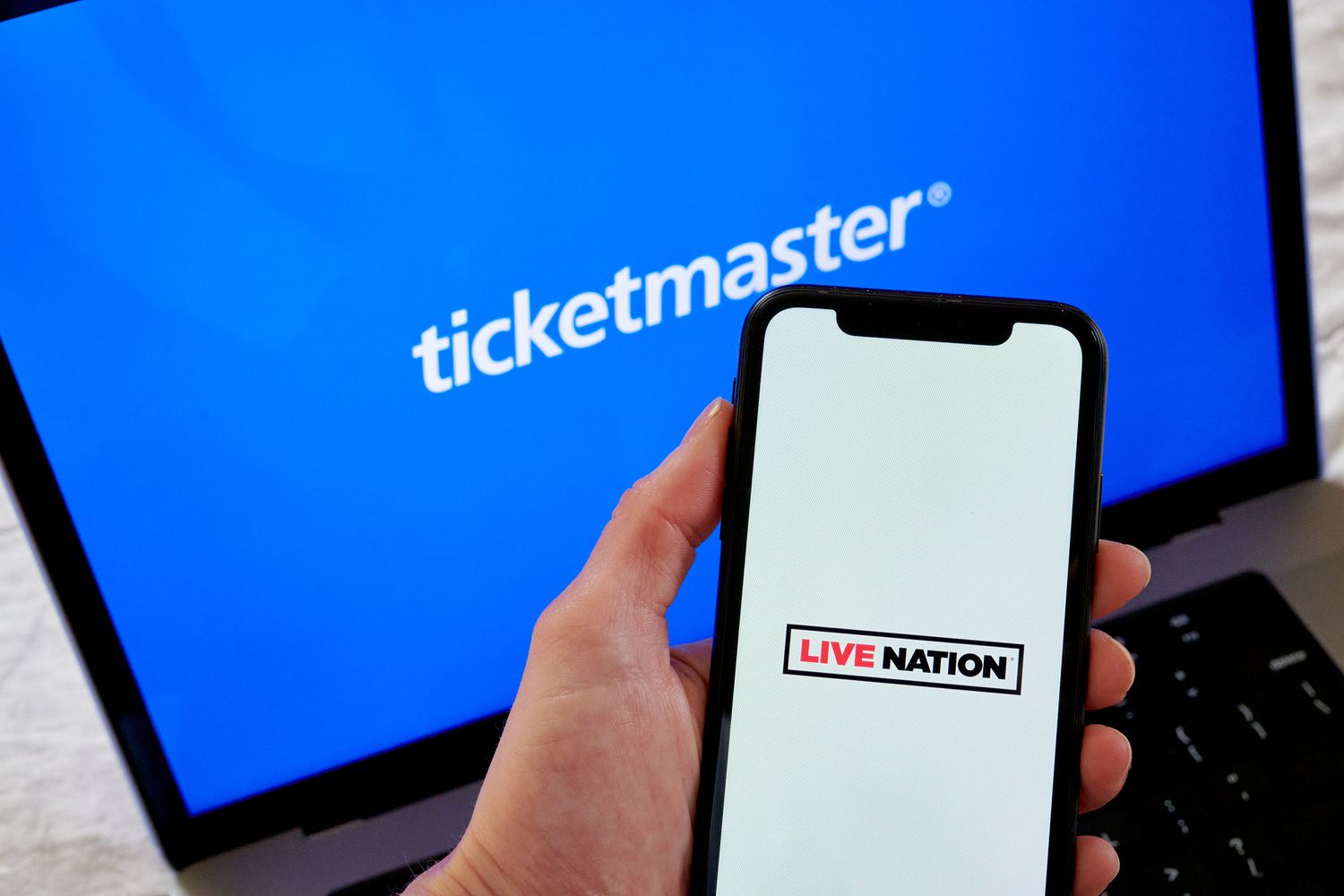 Live Nation and Ticketmaster logos arranged on a smartphone and laptop