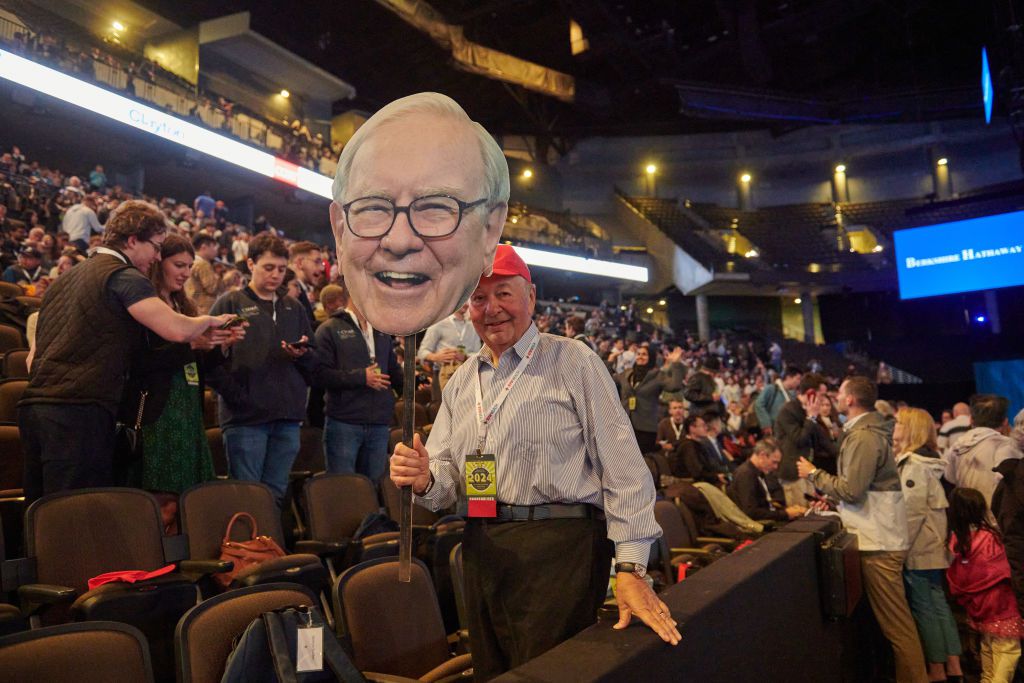 An attendee holds a cardboard cutout of Warren Buffett, chairman and chief executive officer of Berkshire Hathaway Inc., inside the CHI Health Center during the Berkshire Hathaway annual shareholders meeting in Omaha, Nebraska, US, on Saturday, May 4, 2024. 