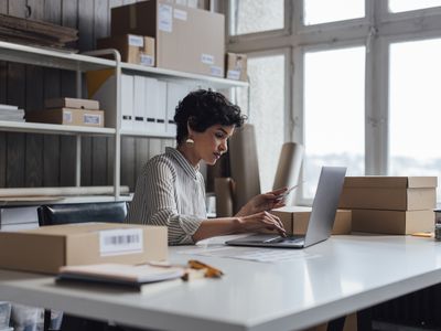 A young small business owner using her laptop computer to check a customer’s order details on her website