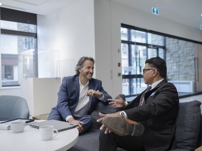 Smiling client talking with financial advisor in bank branch lobby about CD rates