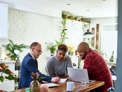 Couple listening to financial advisor at home with laptop 