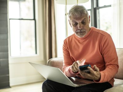 Man looking at laptop and mobile