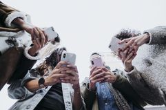 Group of friends in the street with smartphones