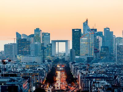 Elevated view of illuminated skyscrapers at La Defense financial district and Avenue des Champs-Elysees at dusk, Paris, France