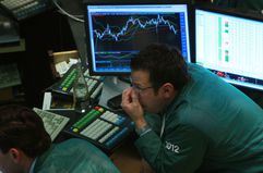 A stock trader working on the floor of the NYSE and analyzing currently over- and under-purchased securities.