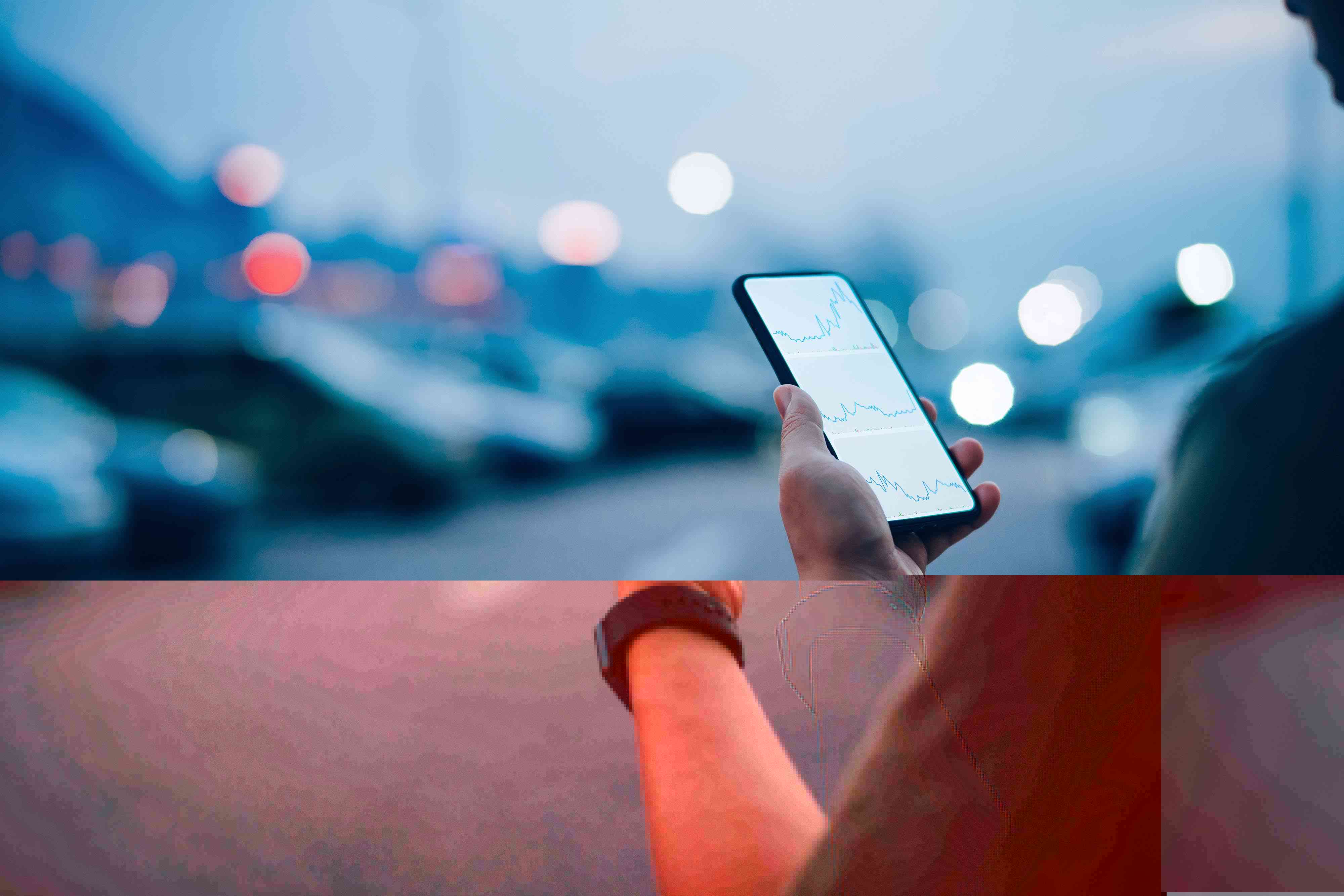 Over the shoulder view of businessman checking financial trading data on smartphone while walking to his car