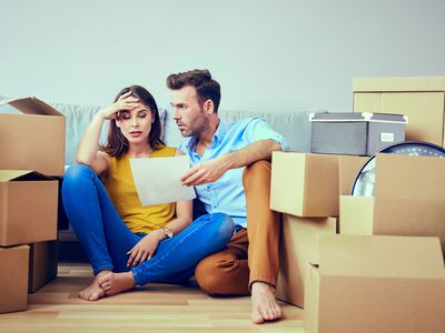 Worried couple reading agreement after moving to new home