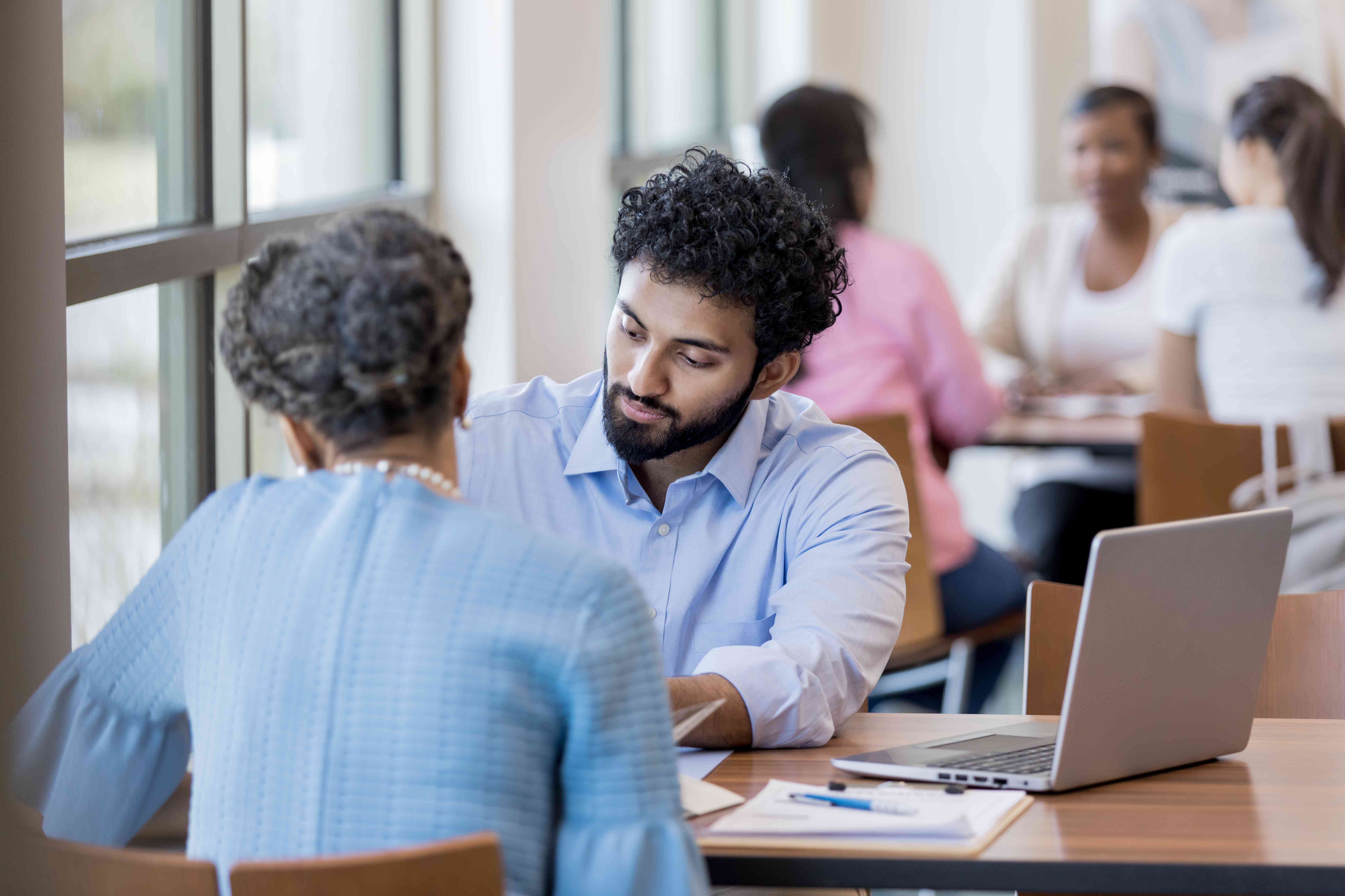 Male banker assists his customer in setting up her CDs