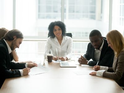 Businessman and businesswoman signing contracts with intermediary in between the two groups