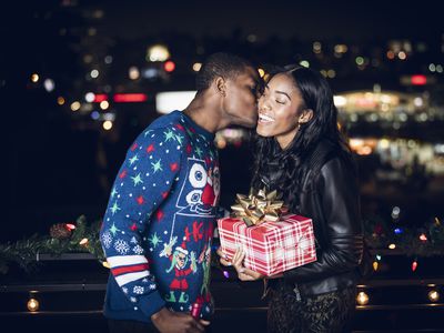 A woman accepting a present and kiss from a male friend