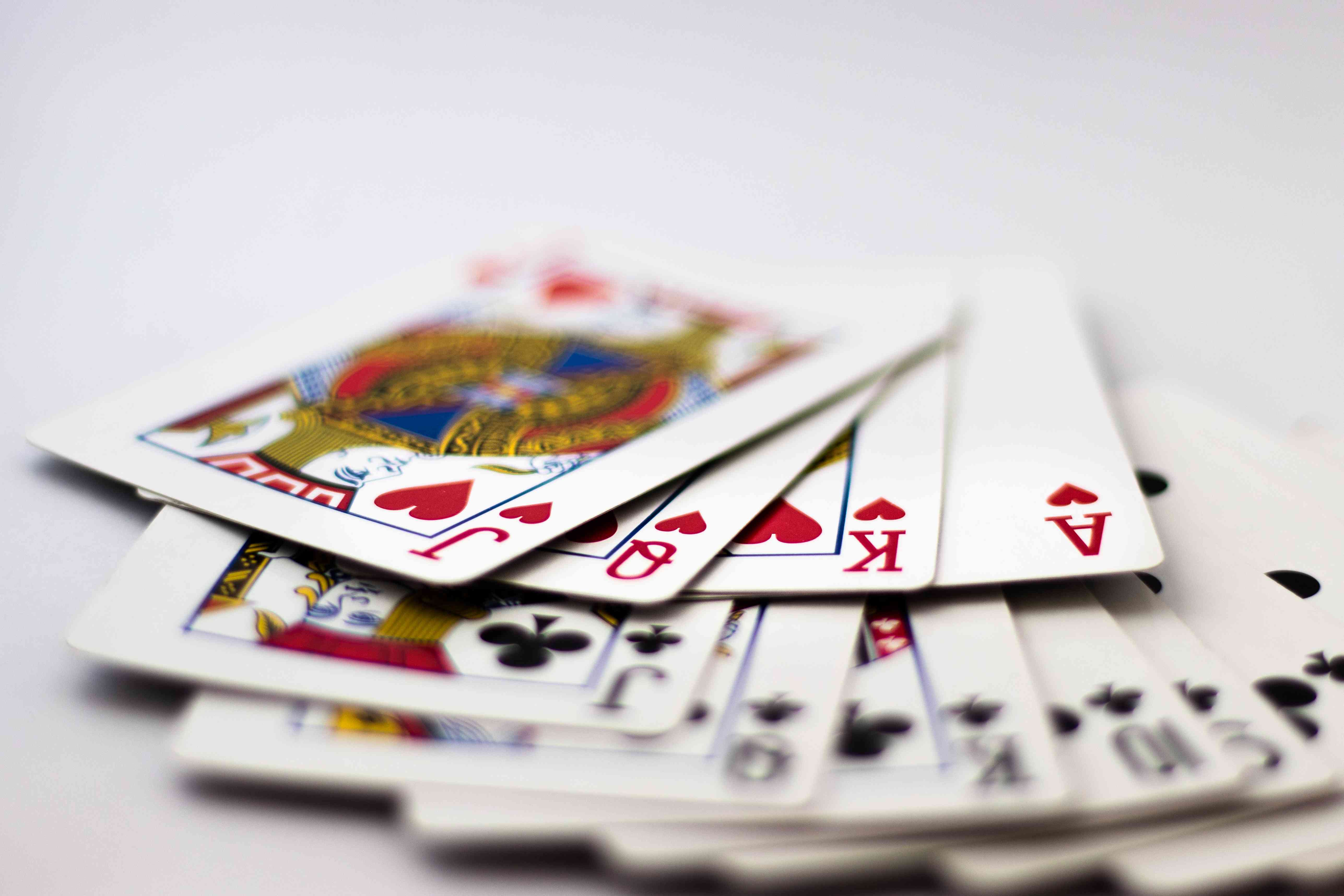 Playing Cards fanned out: Suit of Spades, Clubs and Diamonds fanned out over white background. Gambling, Poker, Win, Lose, Chance, Gambling, Money, Red, Black, Jack, Queen, King