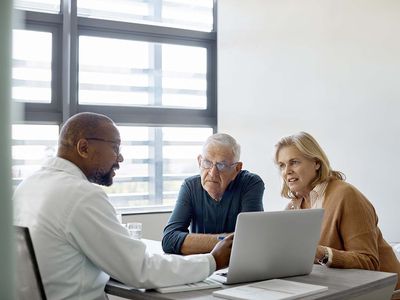 Doctor discussing with senior couple in clinic 