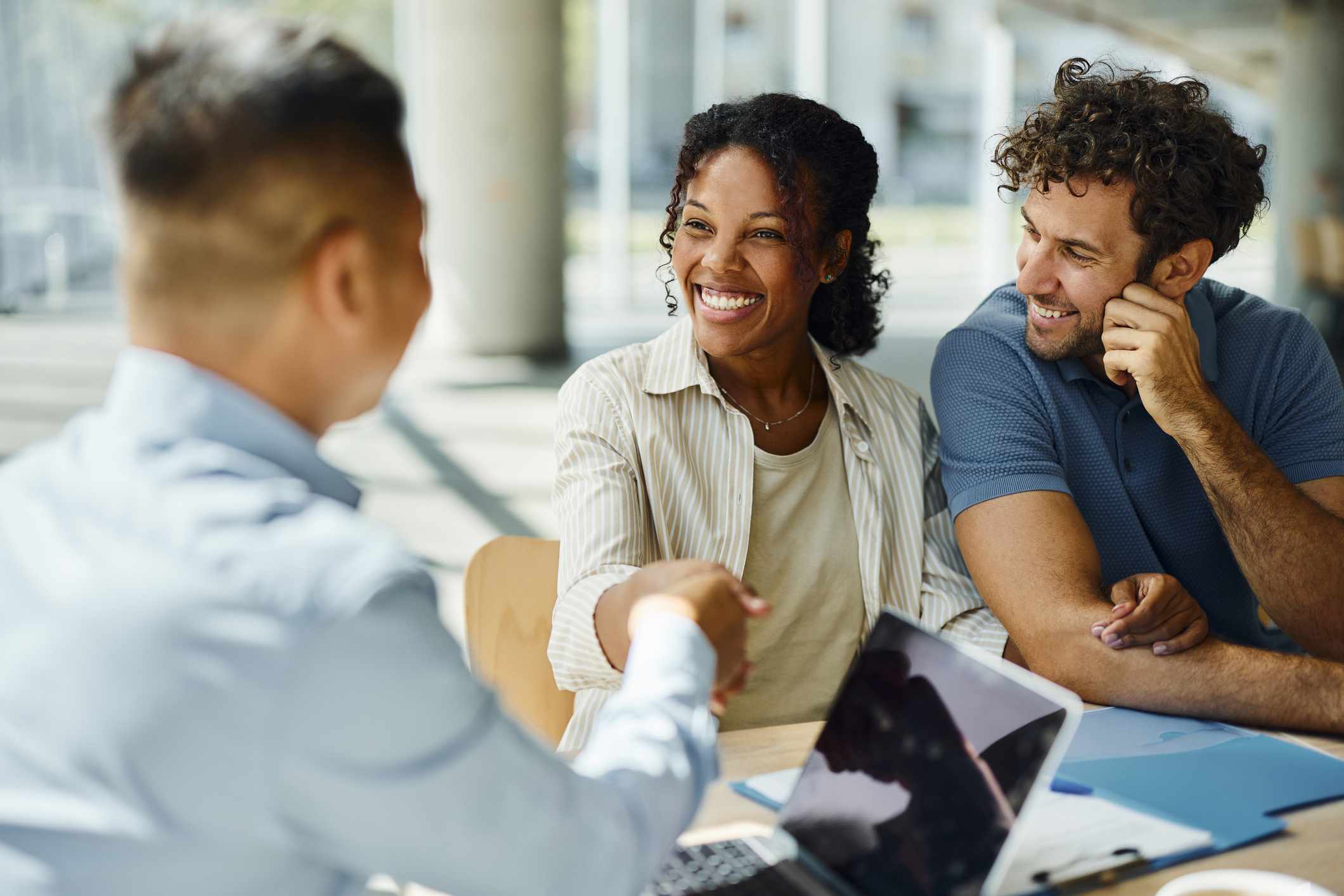 A couple shakes hands with a bank executive.