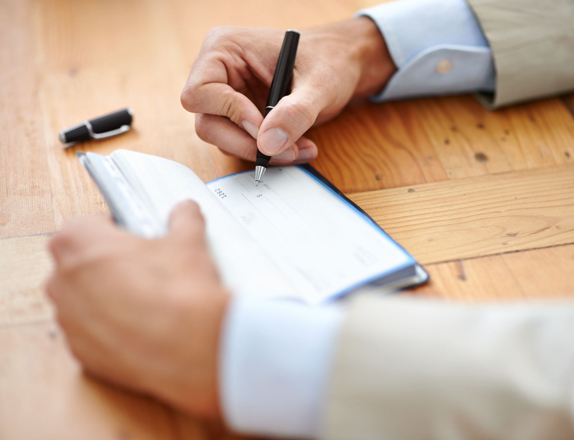 businessman signing cheques.