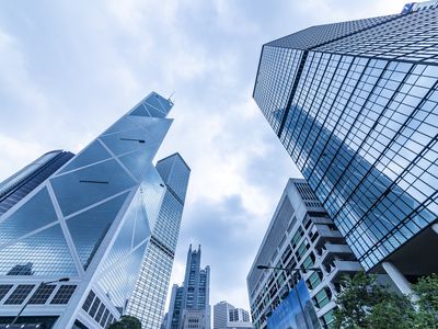 Bottom view of modern skyscrapers in business district against blue sky