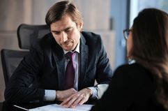 Man looking at paperwork in an office meeting