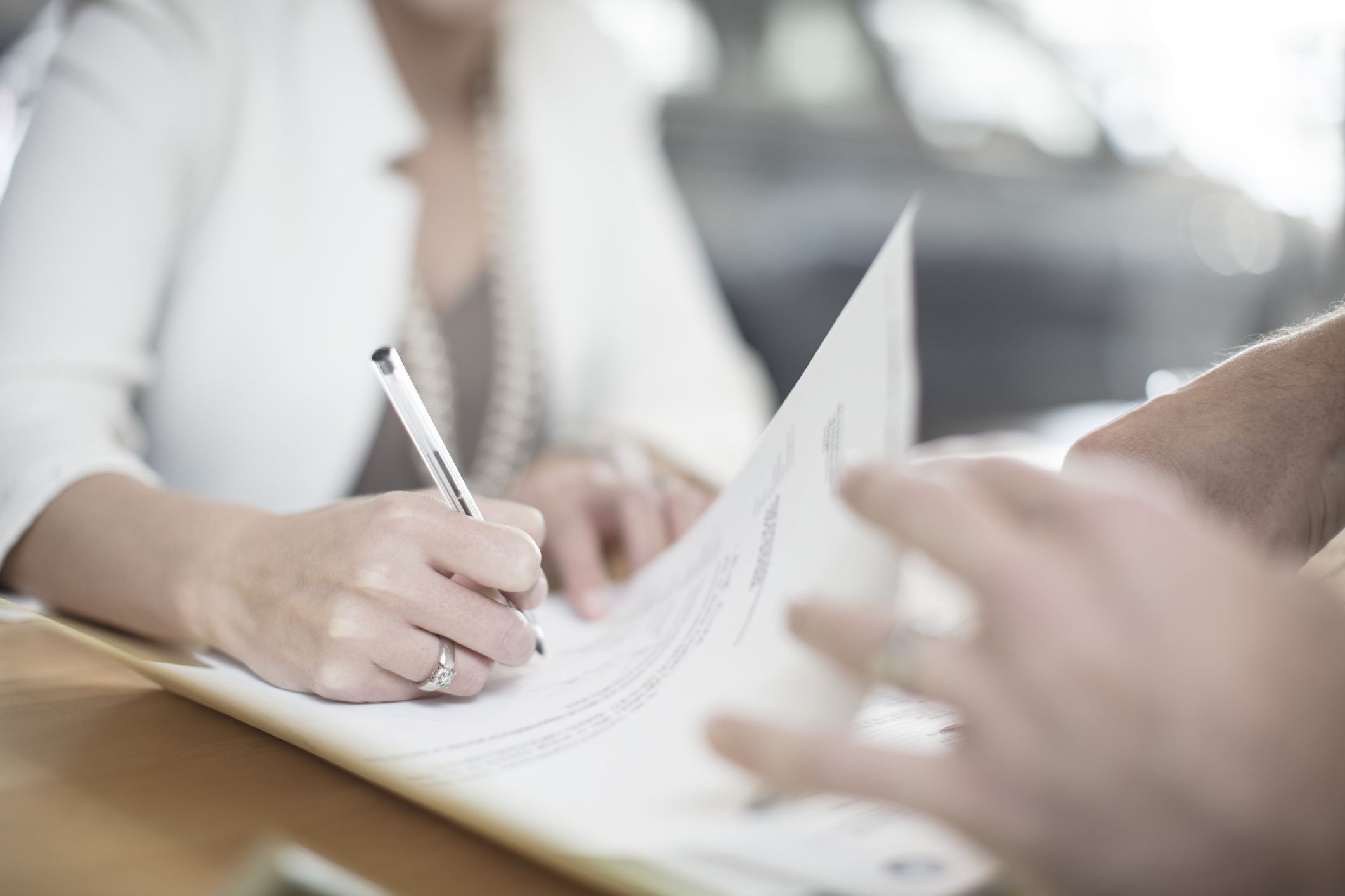 Woman signing forms and letter to insurance company