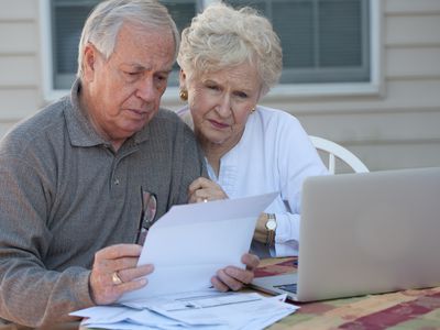 Couple working at a computer with concerned expressions on their faces