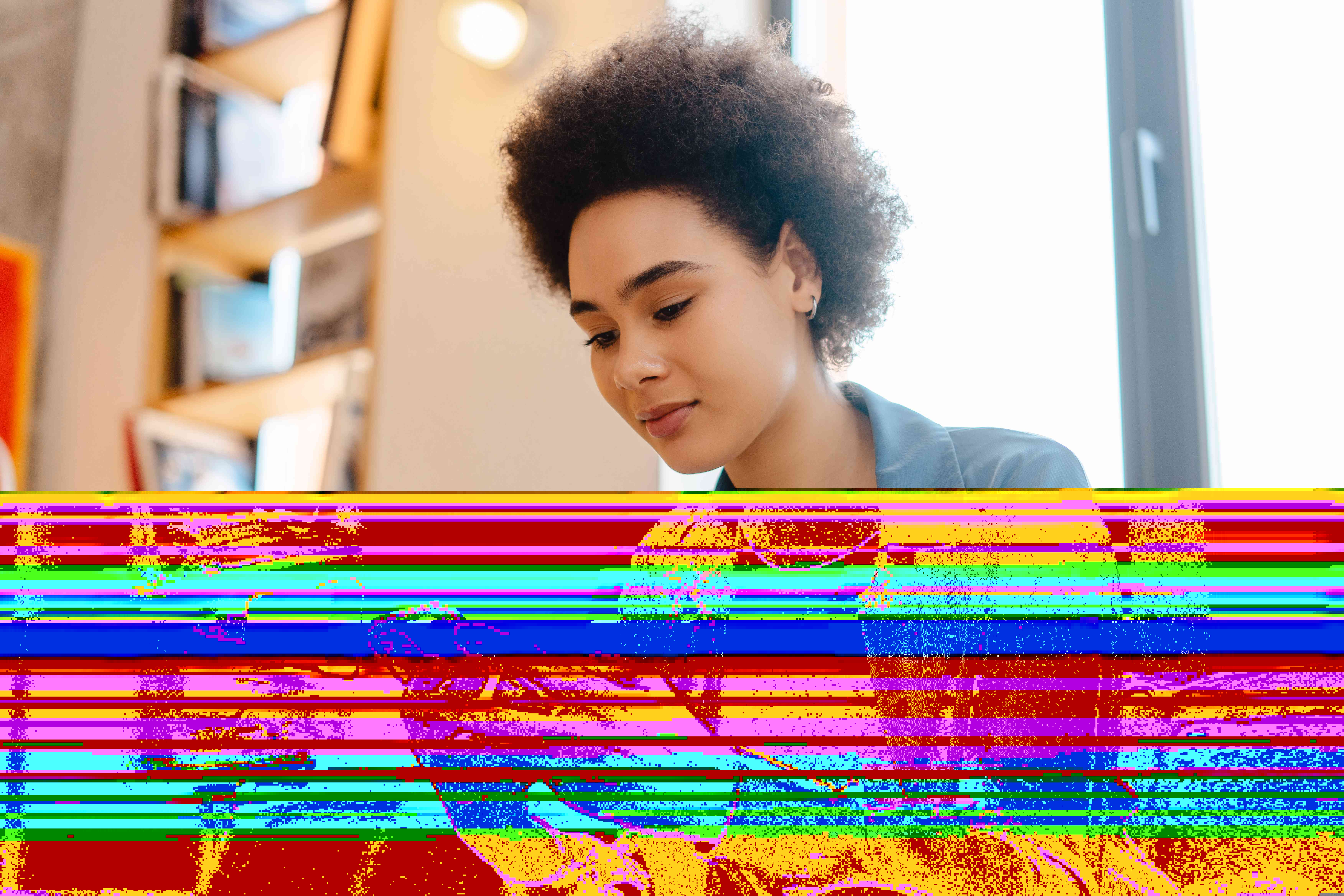 Young woman sitting on couch at home, looking at something on her smartphone