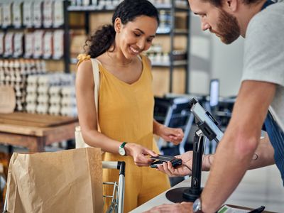 A woman makes a credit card purchase at a store.