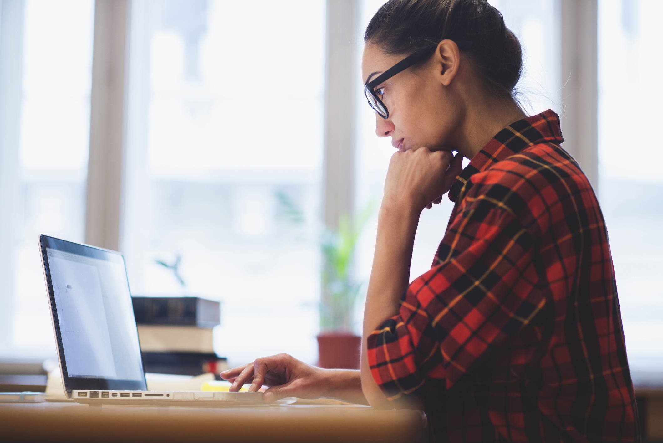 A woman working at a computer using software to analyze qualitative data.