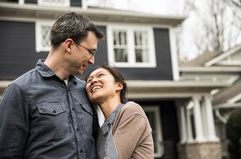 Couple standing in front of a house