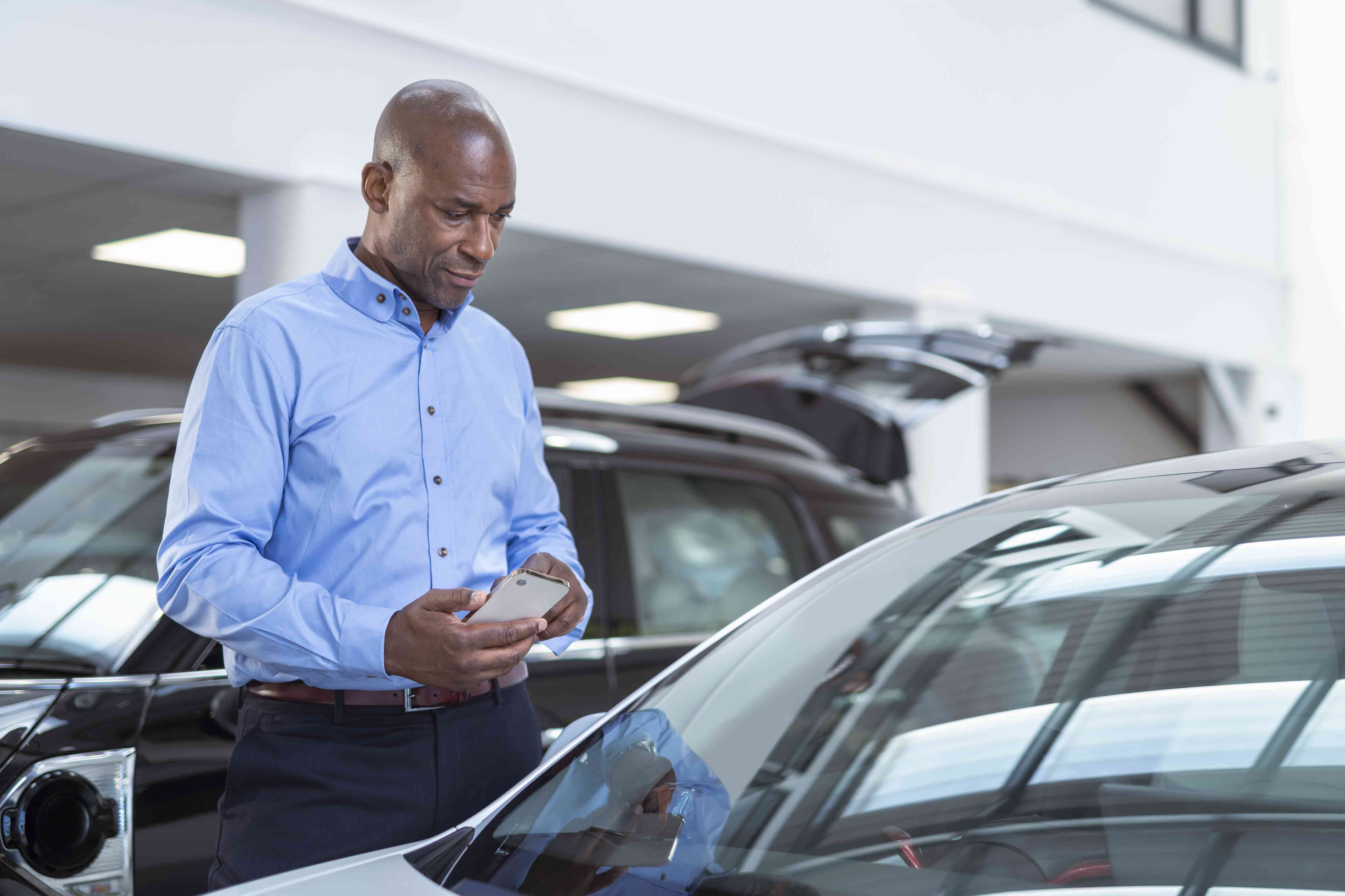 A man looks at cars in a showroom